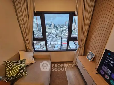 Cozy living room with stunning city view from large windows, perfect for relaxation and urban living.
