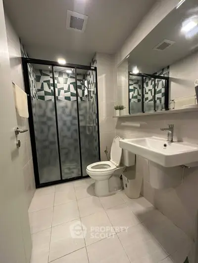 Modern bathroom with sleek shower and contemporary fixtures in stylish apartment.