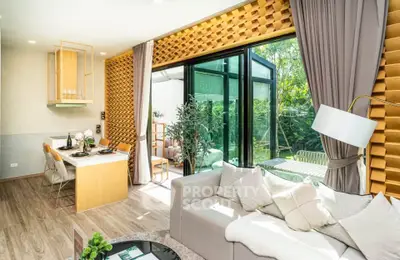 Modern living room with open kitchen and garden view, featuring stylish decor and natural light.