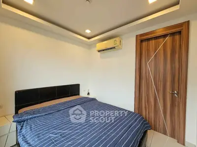 Modern bedroom with stylish wooden door and air conditioning unit, featuring a cozy bed with striped bedding.