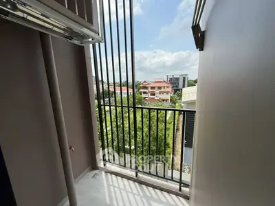 Charming balcony with scenic view of lush greenery and residential area, perfect for relaxation.