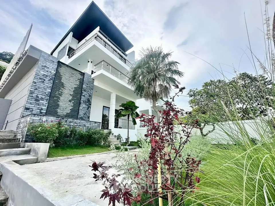 Stunning modern multi-story home with lush garden and sleek architectural design.