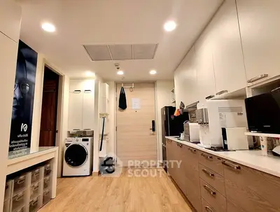 Modern kitchen with sleek cabinetry and built-in appliances in cozy apartment.