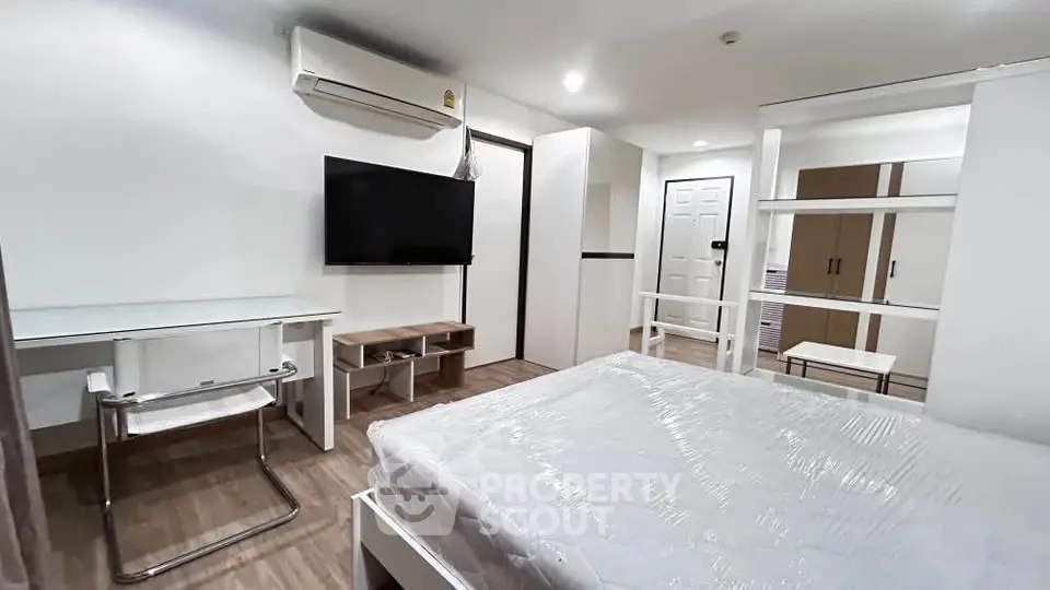 Modern bedroom with air conditioning, TV, and stylish furniture in a cozy apartment.