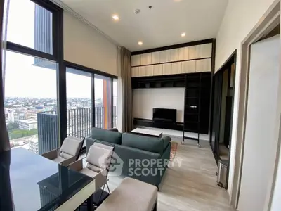 Modern living room with large windows and city view, featuring sleek furniture and built-in shelving.