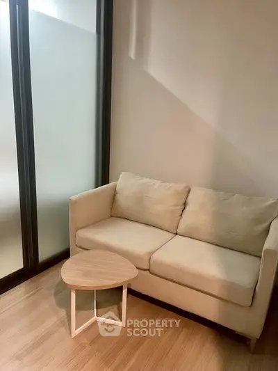 Cozy living room with beige sofa and modern wooden coffee table, perfect for relaxation.