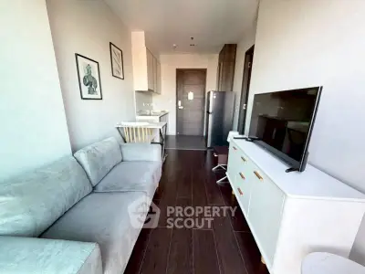 Modern living room with sleek furniture and open kitchen layout in a stylish apartment.