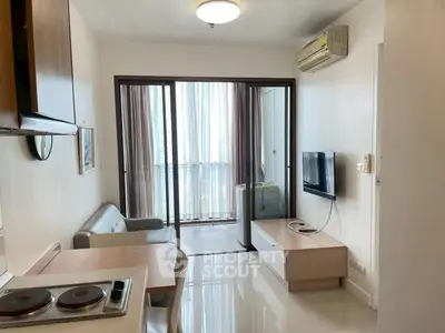 Modern living room with balcony, sleek furniture, and natural light in a stylish apartment.