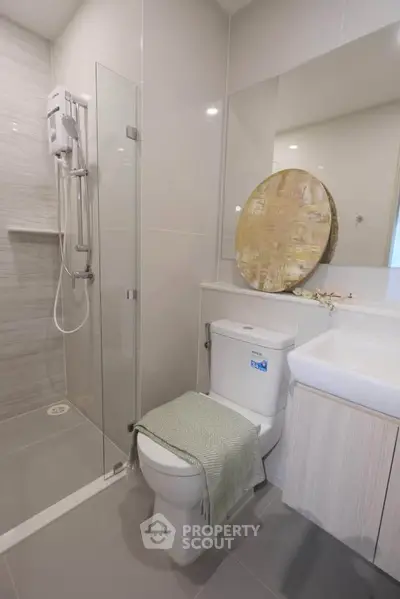 Modern bathroom with glass shower and stylish decor in contemporary apartment.
