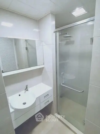 Modern bathroom with sleek shower and vanity in a contemporary apartment.