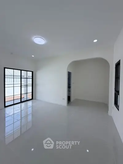 Spacious modern living room with large windows and sleek tile flooring
