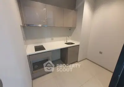 Modern compact kitchen with sleek cabinetry and electric stove