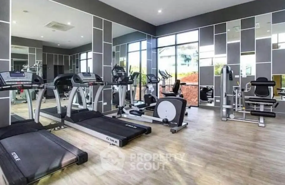 Modern gym with state-of-the-art fitness equipment and mirrored walls in a luxury residential building.