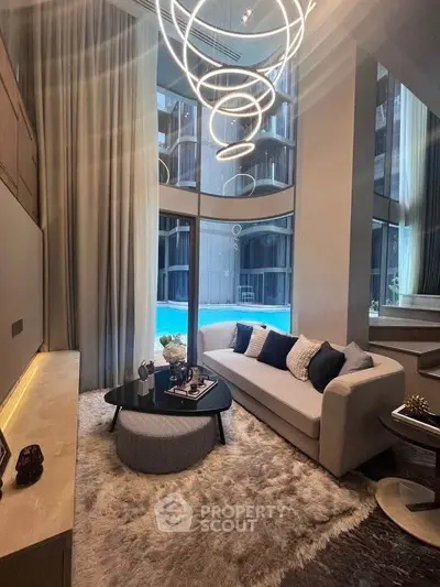 Luxurious living room with modern chandelier and pool view in high-rise apartment