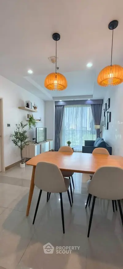 Modern dining area with stylish lighting and large window in a contemporary apartment.