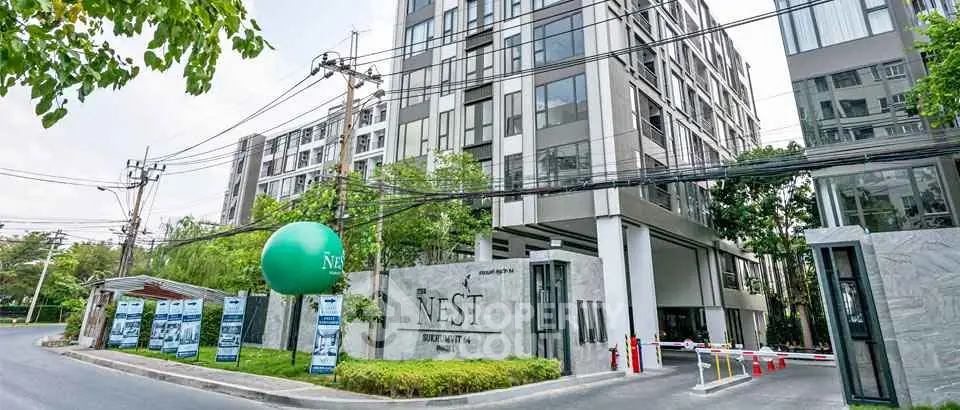 Modern residential building exterior with lush greenery and secure entrance at The Nest.