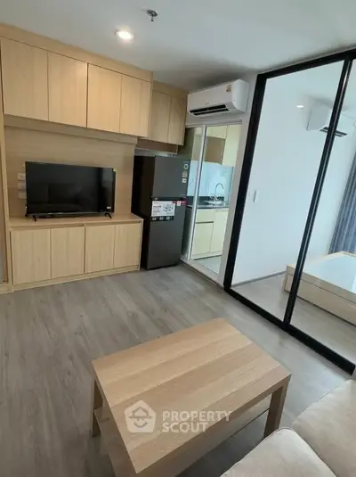 Modern living room with wooden furniture and sliding glass door to bedroom in a stylish apartment.