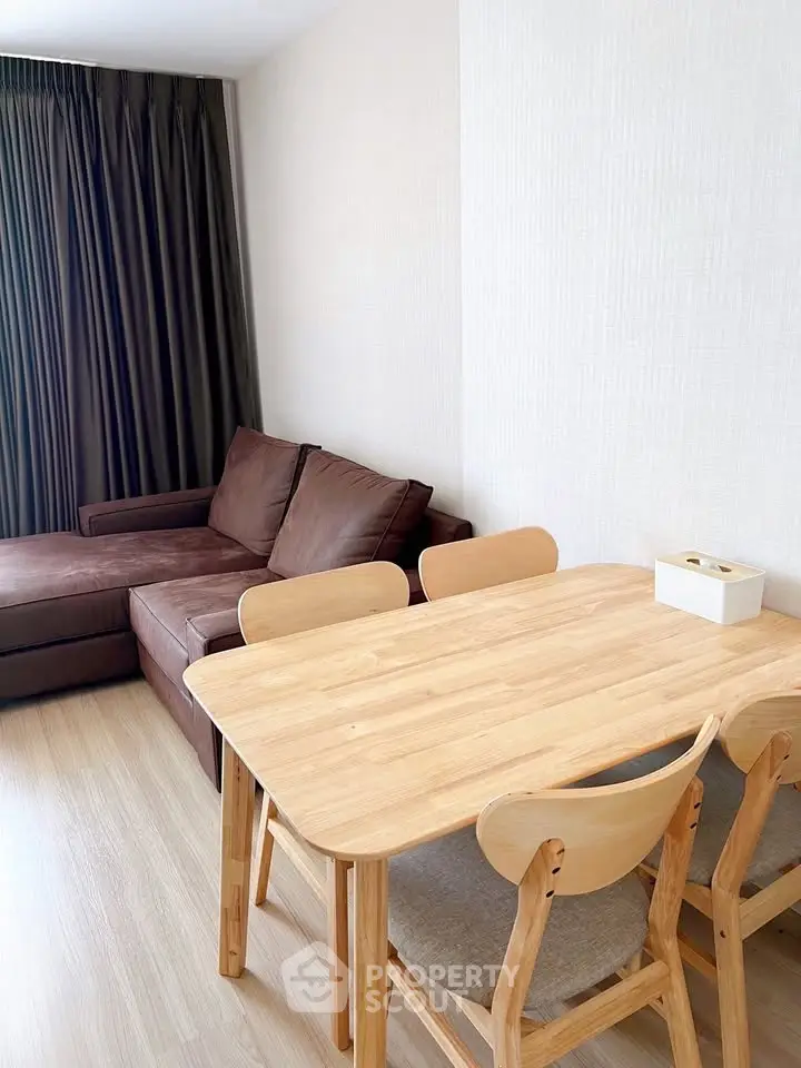 Modern living room with cozy brown sofa and wooden dining set, perfect for urban living.