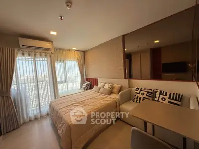 Modern bedroom with cozy decor and large windows offering natural light