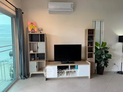Modern living room with sleek TV stand, air conditioning, and stylish decor.