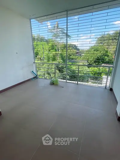 Spacious balcony with lush green view, perfect for relaxation and outdoor enjoyment.