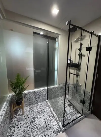 Modern bathroom with stylish glass shower and patterned tile flooring