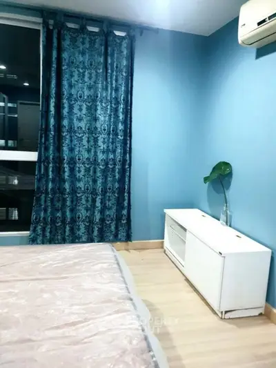 Cozy bedroom with blue walls, elegant curtains, and air conditioning for comfort.
