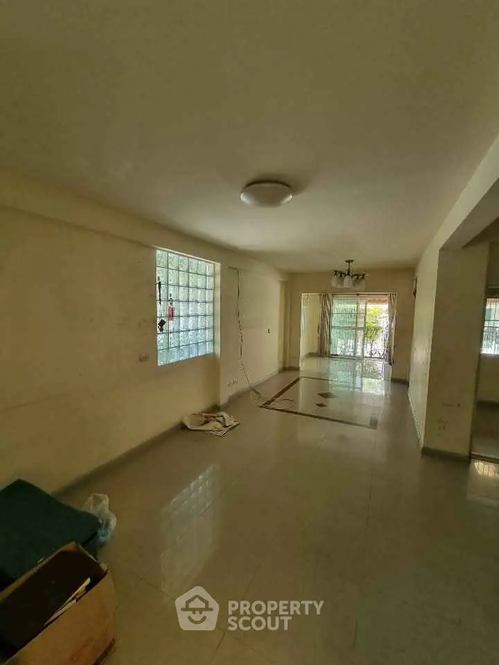 Spacious living room with large windows and tiled flooring, ideal for customization.