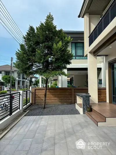 Modern home exterior with spacious patio and lush greenery