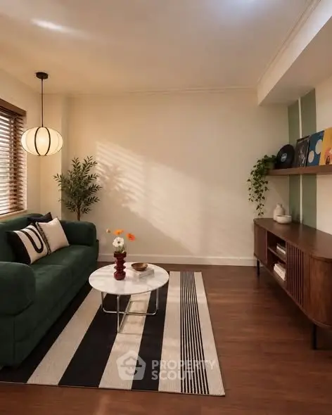Stylish living room with modern decor, green sofa, and elegant lighting.