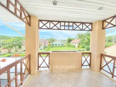 Charming balcony with scenic view of suburban homes and lush greenery.
