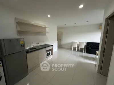 Modern open-layout kitchen and living area with sleek appliances and minimalist design.