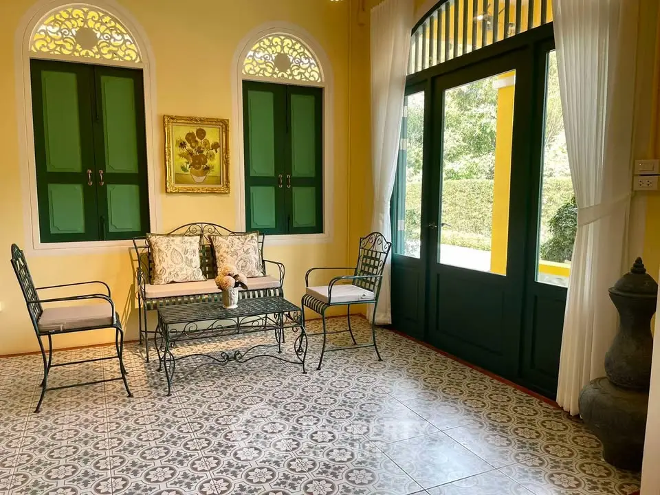 Charming sunlit room with vintage decor and elegant wrought iron furniture.