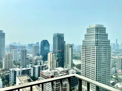 Stunning cityscape view from a high-rise balcony overlooking modern skyscrapers and urban skyline.