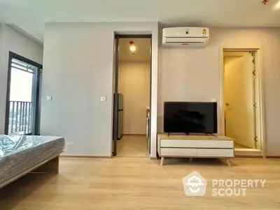 Modern apartment interior with wooden flooring, air conditioning, and balcony view.