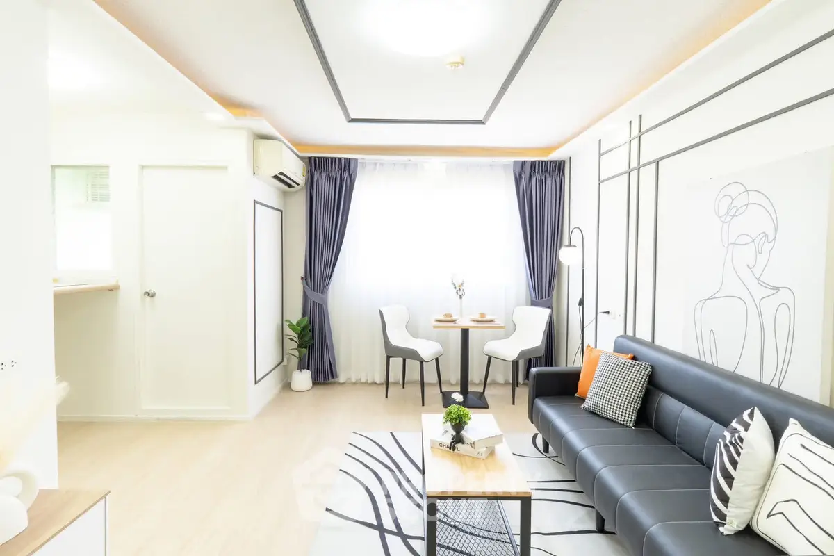 Modern living room with stylish decor, featuring a sleek black sofa, elegant curtains, and a cozy dining area.