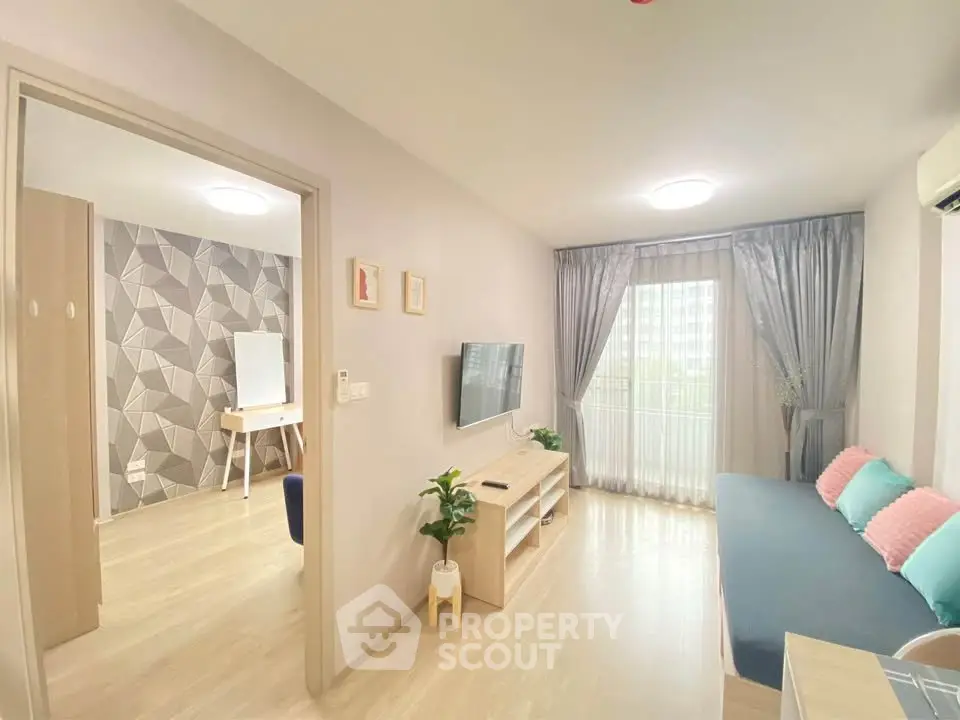 Modern living room with stylish decor and natural light, featuring a cozy sofa and wall-mounted TV.
