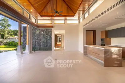 Luxurious open-plan living room with high wooden ceiling and garden view