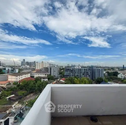 Stunning cityscape view from a high-rise balcony with clear blue skies.