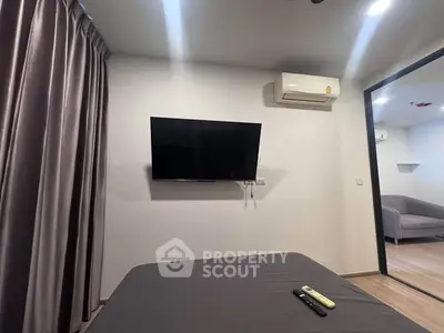 Modern bedroom with wall-mounted TV and air conditioning unit, featuring sleek curtains and a cozy ambiance.