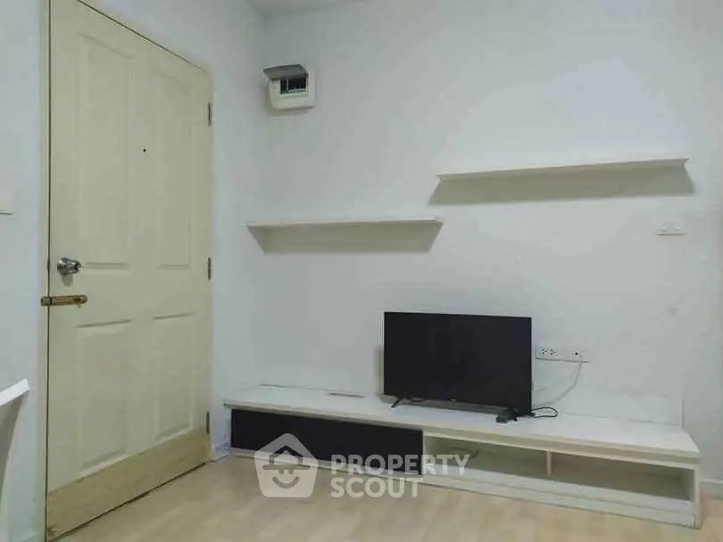 Minimalist living room with TV and shelves, perfect for modern urban living.