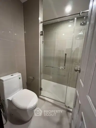 Modern bathroom with glass shower enclosure and sleek fixtures.