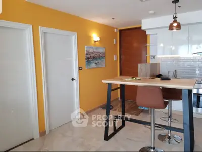 Modern kitchen with open layout, featuring a stylish breakfast bar and vibrant yellow accent wall.