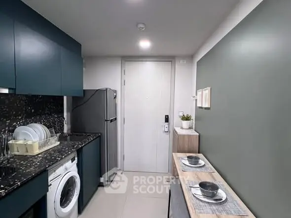 Modern kitchen with sleek cabinetry and integrated appliances in compact layout.