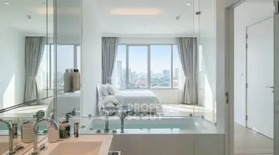 Luxurious bedroom with ensuite bathroom featuring a modern bathtub and stunning city view.