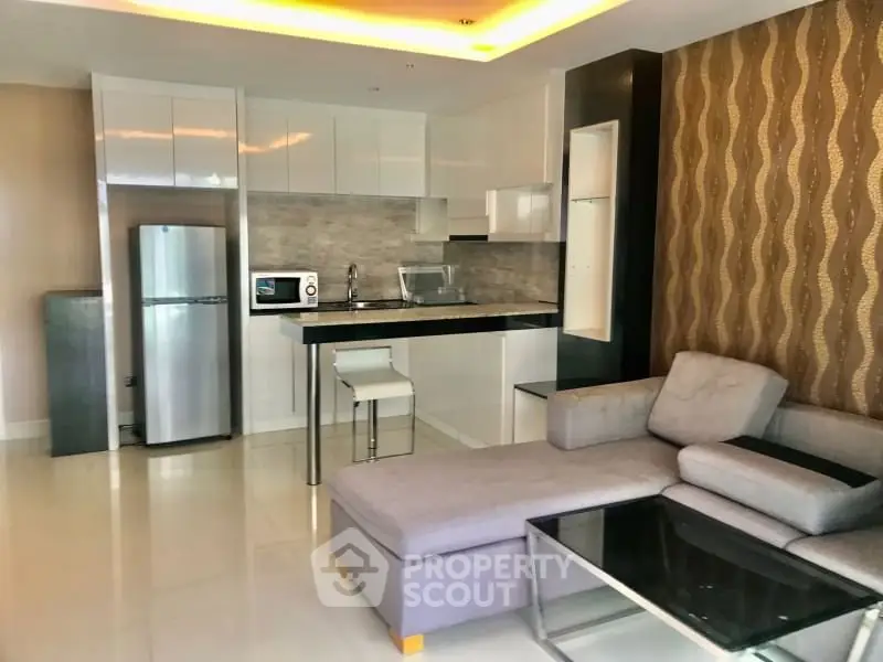 Modern open-layout kitchen and living room with sleek design and stylish furniture.
