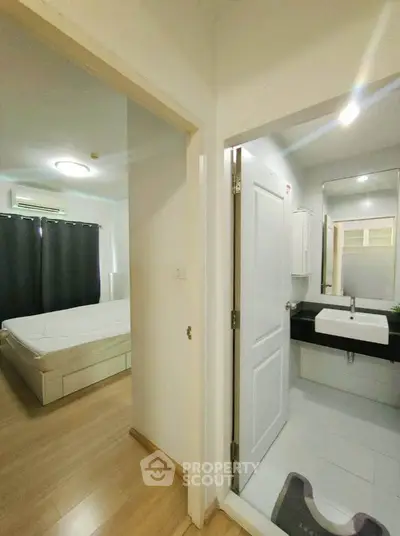 Modern apartment interior with bedroom and bathroom, featuring sleek design and natural lighting.