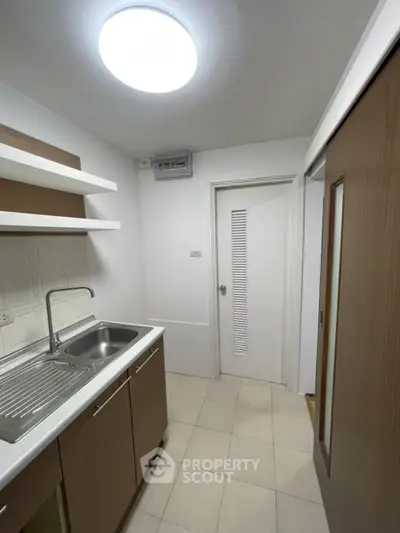 Compact kitchen with modern sink and ample storage in a cozy apartment