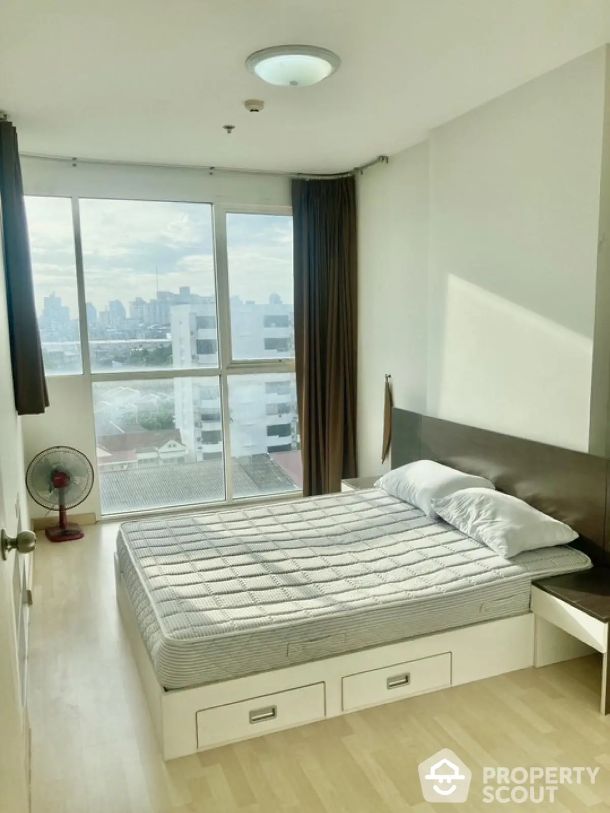 Modern bedroom with city view and natural light in high-rise apartment