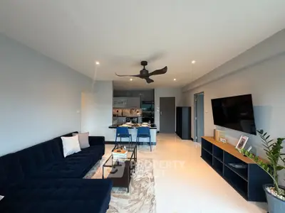 Modern living room with sleek furniture and open kitchen layout, perfect for contemporary living.